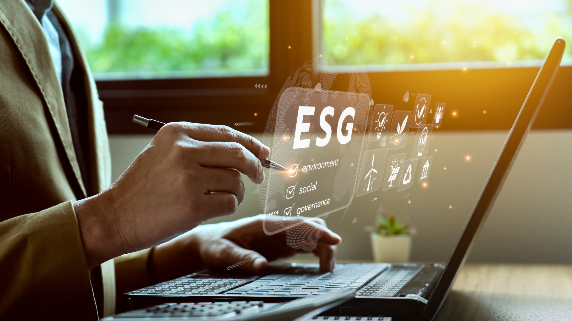 Professionnel pointant avec un stylo une interface virtuelle ESG (environnement, social, gouvernance) au-dessus d'un ordinateur portable