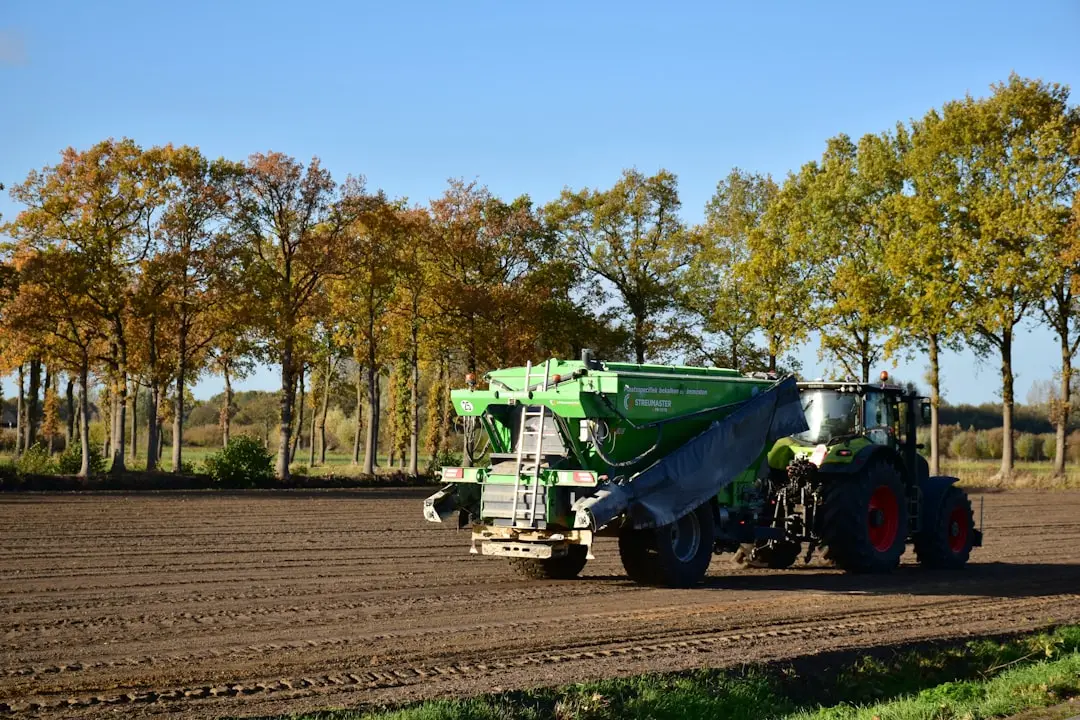 Un tracteur roule sur un chemin de terre.