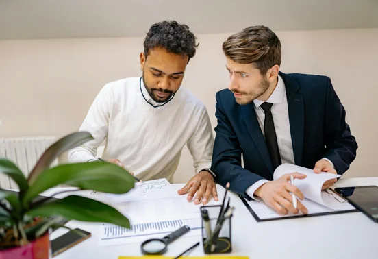 Deux collègues en discussion autour de documents