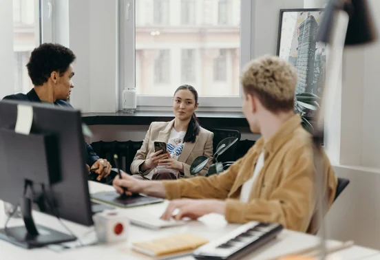 3 personnes assises dans un bureau