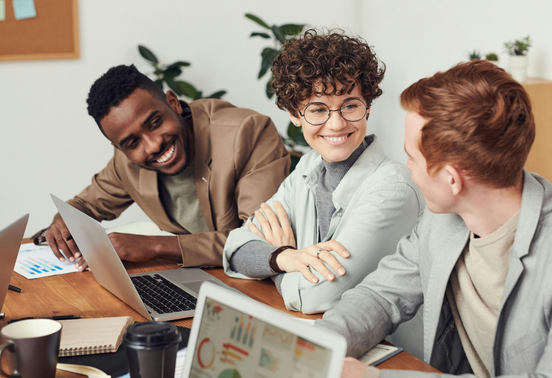 Collaborateurs échangeant autour d’un ordinateur lors d’une réunion professionnelle en entreprise.