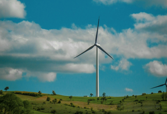 Éolienne installée dans un paysage de campagne, illustrant la production d’électricité renouvelable.