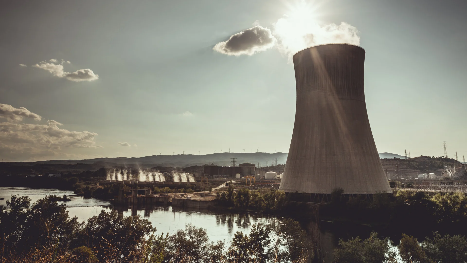 Centrale nucléaire au bord d’un fleuve, illustrant la production d’électricité et les enjeux liés à l’énergie.