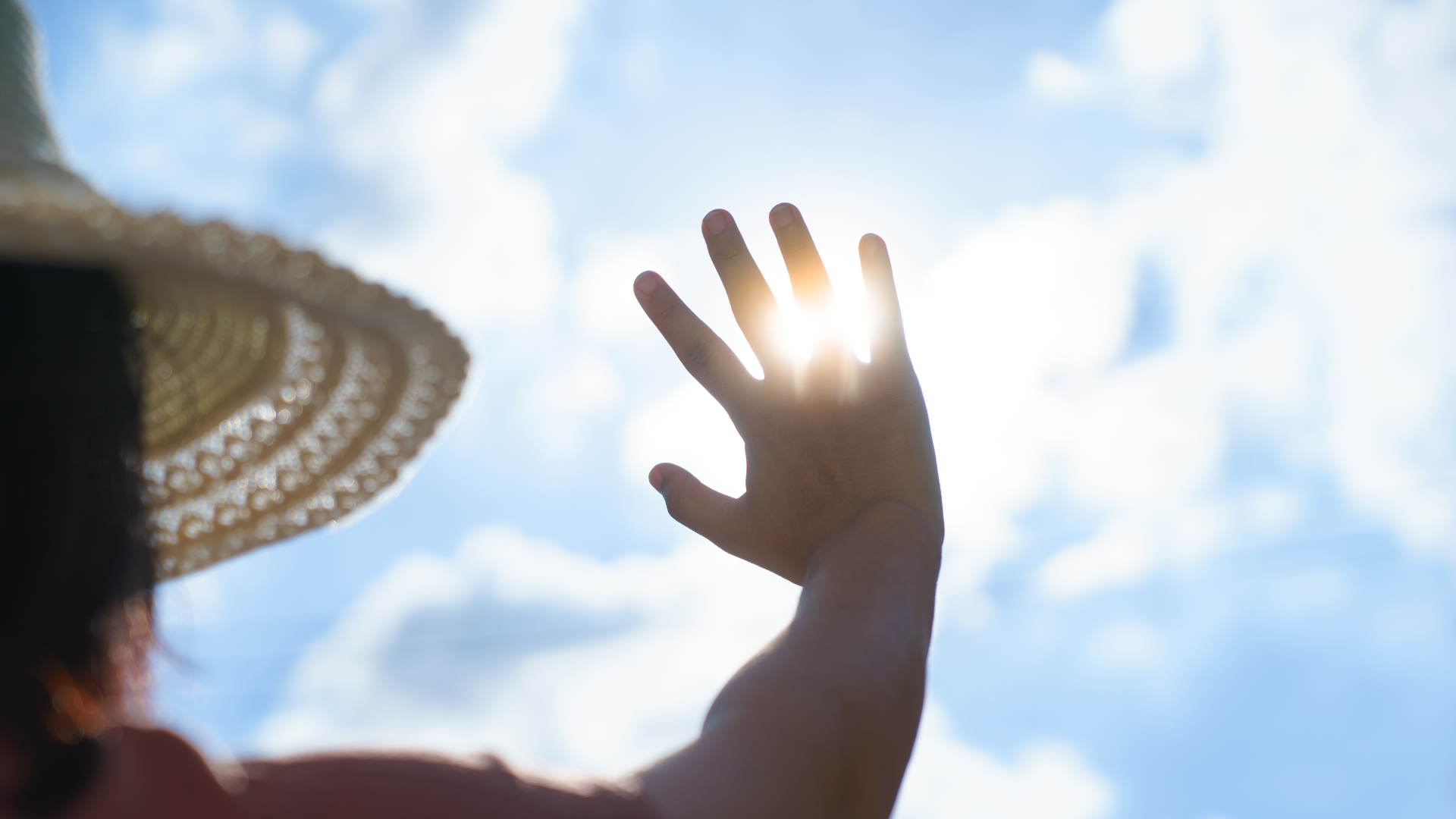 Personne se protégeant du soleil avec la main, illustrant une période de canicule et de fortes chaleurs.
