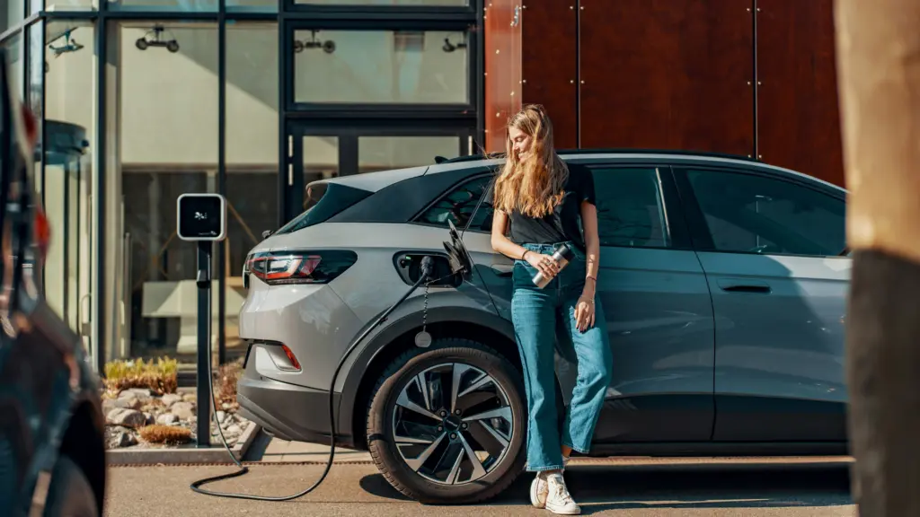 Voiture électrique de fonction en recharge sur une borne devant un bâtiment d'entreprise