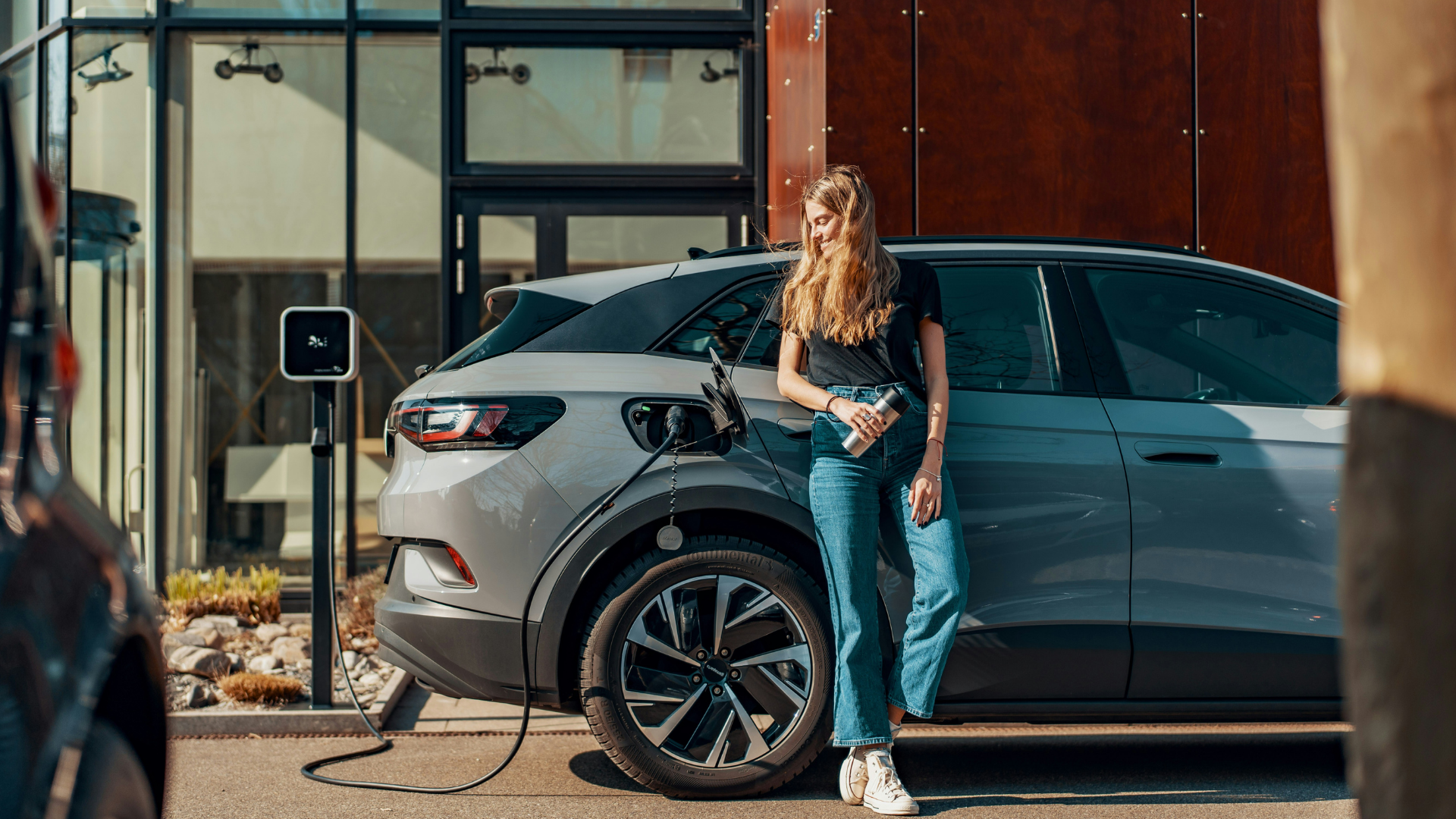 Voiture électrique de fonction en recharge sur une borne devant un bâtiment d'entreprise