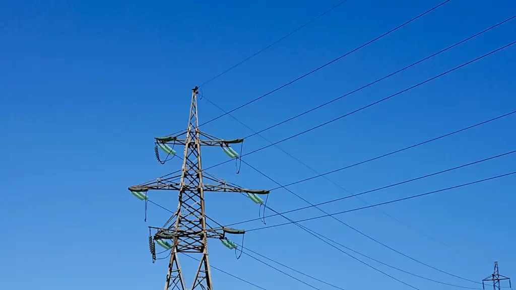 Pylône électrique haute tension et lignes sous un ciel bleu dégagé, illustration du réseau français lors du bilan électrique de l'été 2026