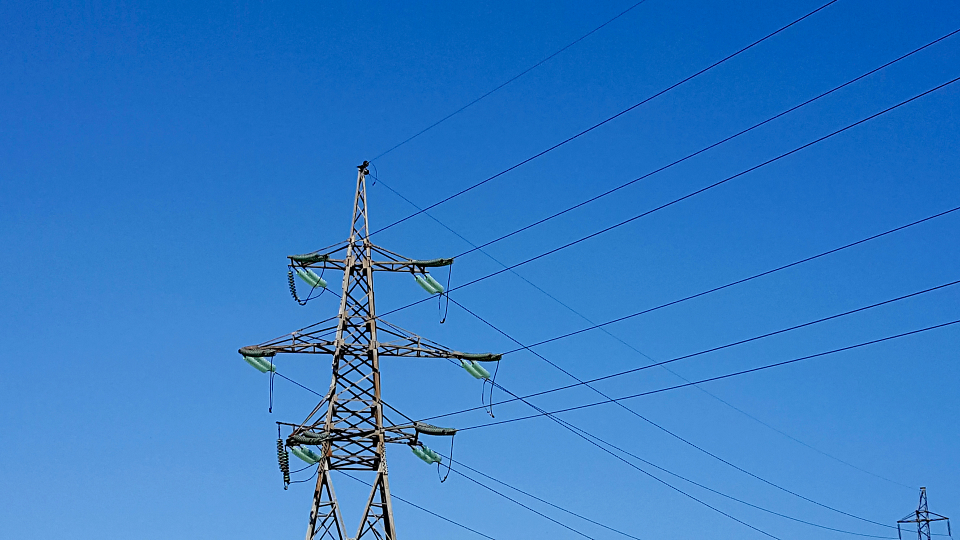 Pylône électrique haute tension et lignes sous un ciel bleu dégagé, illustration du réseau français lors du bilan électrique de l'été 2026